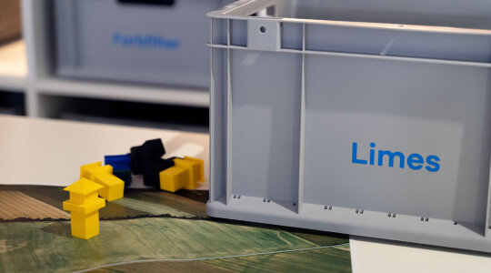 graue Box mit Aufschrift Limes; daneben Spielfiguren in Form eines Wachturms